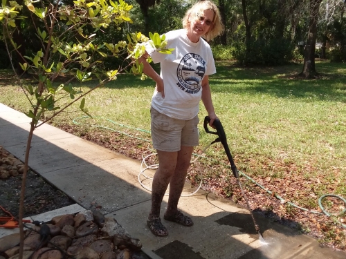 Leslie pressure washing the sidewalk.