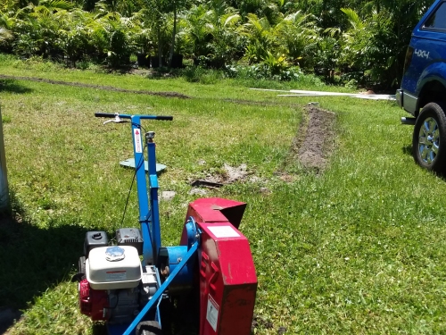 Using a power trencher to put in sprinkler lines.